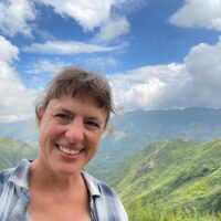 Gayle Volk with view of Vietnam hilltops and clouds behind